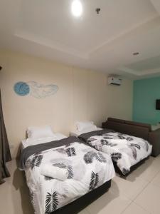 duas camas sentadas uma ao lado da outra num quarto em Rustic one bedroom unit for 4 pax with Sea View by JoMy Homestay em Lumut