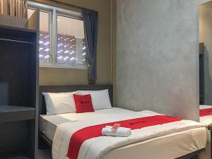 um quarto com uma cama com almofadas vermelhas e uma janela em RedDoorz near Wisata Paribendo Lawang em Bukit Lawang