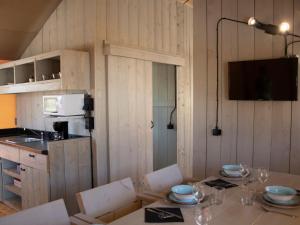a dining room with a table and a kitchen at Camping Colombres in Colombres