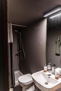 a bathroom with a sink and a toilet and a shower at Luxury Suite in Heerewaarden