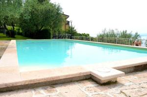a large swimming pool with blue water at Maison Balù Villa in Torri del Benaco
