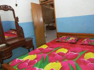 een slaapkamer met een bed met bloemen erop bij Pondok Galang in Pangandaran +4 foto's