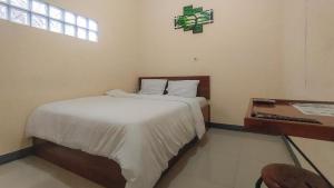 A bed or beds in a room at RedDoorz @ Merauke City Center