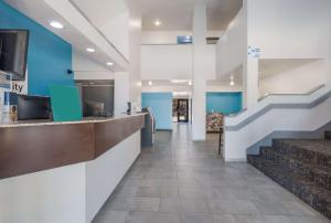 a lobby of a hospital with blue walls and stairs at Quality Inn & Suites Richardson-Dallas in Richardson