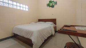 Uma cama ou camas num quarto em RedDoorz @ Merauke City Center