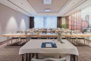 a conference room with tables and chairs and a large window at Best Western Plus Hotel Böttcherhof in Hamburg