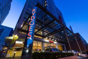 a building with a sign for a car dealership at Rydges Auckland in Auckland