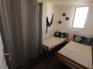 two twin beds in a room with a window at Le Carlton - Superbe Appartement - Accès direct plage - Terrasse Vue mer in Leucate