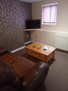 ein Wohnzimmer mit einem Sofa und einem Couchtisch in der Unterkunft clazzers apartment 3 in Bridlington