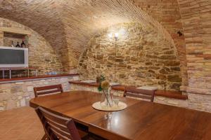 uma sala de jantar com uma mesa e uma parede de pedra em Battisti 55 - YourPlace Abruzzo em Rocca San Giovanni