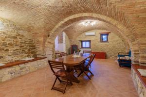 uma sala de jantar com uma mesa e uma parede de tijolos em Battisti 55 - YourPlace Abruzzo em Rocca San Giovanni