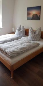 ein großes Bett mit zwei Kissen darüber in der Unterkunft An den Elbwiesen in Dresden