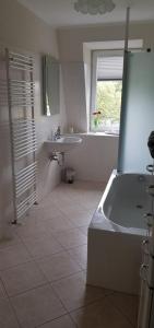 ein weißes Badezimmer mit einer Badewanne und einem Waschbecken in der Unterkunft An den Elbwiesen in Dresden
