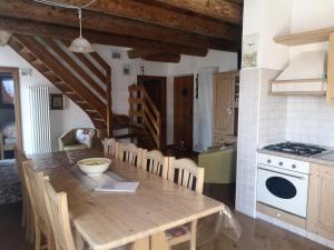 una cucina con tavolo in legno e alcune sedie di Agritur Maso Gosserhof a Frassilongo