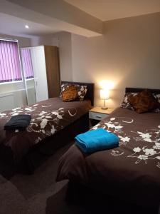 a bedroom with two beds and a table with a lamp at clazzers apartment 3 in Bridlington