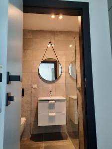 a bathroom with a sink and a mirror at Apartament nad jeziorem Bory Tucholskie Charzykowy in Charzykowy