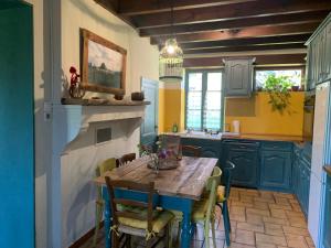 a kitchen with a wooden table and blue cabinets at Les feuilles jaunes in Chantenay-Saint-Imbert