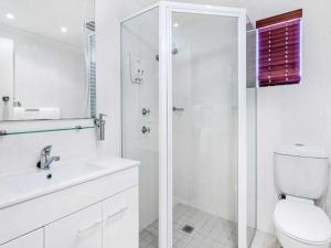 
a bathroom with a shower, toilet and sink at Country Plaza Motel Taree in Taree
