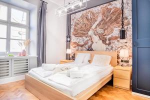 - une chambre avec un grand lit et des draps blancs dans l'établissement AT Krakow Apartments, à Cracovie