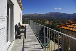 uma varanda com mesa, cadeiras e montanhas em Apartment Marita em Cilipi