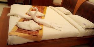 łóżko z dwoma łabędzie wykonanymi z ręczników w obiekcie Hotel Aradhana Inn w mieście Yercaud