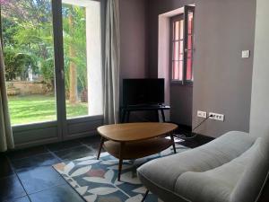 a living room with a couch and a table and a television at B&B Villa Roumanille in Aix-en-Provence