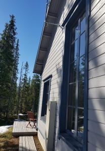 una casa con una puerta y una silla en un porche en Air-conditioned holiday home Vutnusmaja at Iso-Syöte, en Syöte