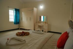 a bedroom with a large bed with two towels on it at Hotel Aradhana Inn in Yercaud