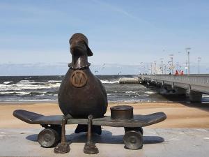 a statue of a duck on a skateboard on the beach at Marina Apartments in Kołobrzeg