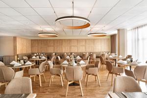 un ristorante con tavoli e sedie in una stanza di H+ Hotel Köln Brühl a Brühl