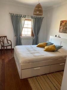 um quarto com uma cama com cortinas azuis e uma janela em Casa da Azinhaga em Alenquer