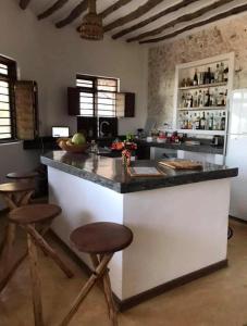 a kitchen with a large counter with stools in it at The Loft Zanzibar Kikadini Beach in Jambiani
