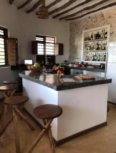 a kitchen with a large counter with stools in it at The Loft Zanzibar Kikadini Beach in Jambiani +33 photos