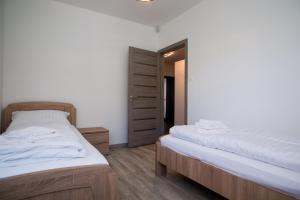 a bedroom with two beds and a mirror at Villa Linett in Siófok