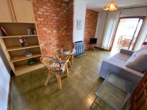 uma sala de estar com um sofá e uma parede de tijolos em Apartamentos Neptuno Altamar em Alcossebre