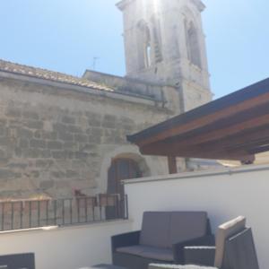 een patio met 2 stoelen en een gebouw met een klokkentoren bij B&B Dei Cardinale in Bari