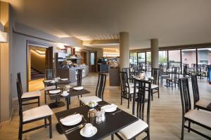 a restaurant with black tables and chairs and a counter at Alevic Hotel Sirmione in Sirmione