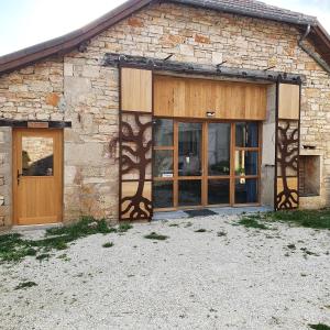 CalvignacにあるL'Oseraie du Quercyの木製のドアと窓のある石造りの家