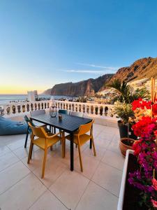 una mesa y sillas en un patio con vistas al océano en Luxury penthouse with breathtaking views and huge private terraces, en Puerto de Santiago