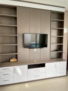 a large white entertainment center with a flat screen tv at Blue Breeze Villa in Lajor