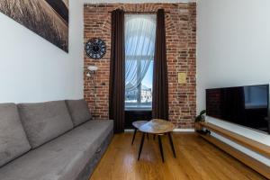 uma sala de estar com um sofá e uma parede de tijolos em Two-story Loft Apartments 15 em Talin