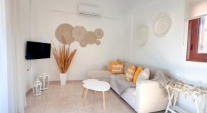 アギオス・ニコラオスにあるCasa con vista Apartmentの白いリビングルーム(ソファ、テーブル付)