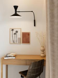 a desk with a black lamp and a chair at Le Mirage in Bormes-les-Mimosas