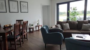 uma sala de estar com um sofá, uma mesa e cadeiras em Fewo Elbkilometer 311 em Schönebeck