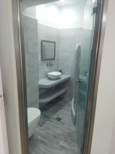 a bathroom with a sink and a toilet and a mirror at Ira Apartments in Kamari
