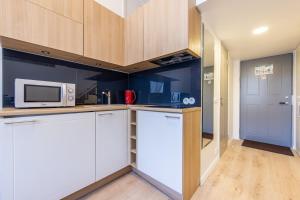 a kitchen with white cabinets and a microwave at Small Cozy two-level Apartments 9 in Tallinn