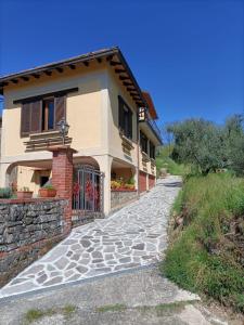 a house with a stone path next to a building at Case La Sassa in Marliana