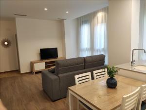 salon z kanapą i stołem w obiekcie Iberflat Apartamentos Trinidad w mieście Castellón de la Plana