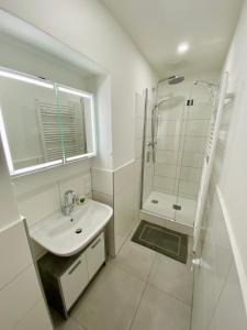 a white bathroom with a sink and a shower at Apartment Katrin im Zentrum in Bad Ischl