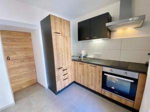 a kitchen with wooden cabinets and a stove top oven at Apartment Katrin im Zentrum in Bad Ischl